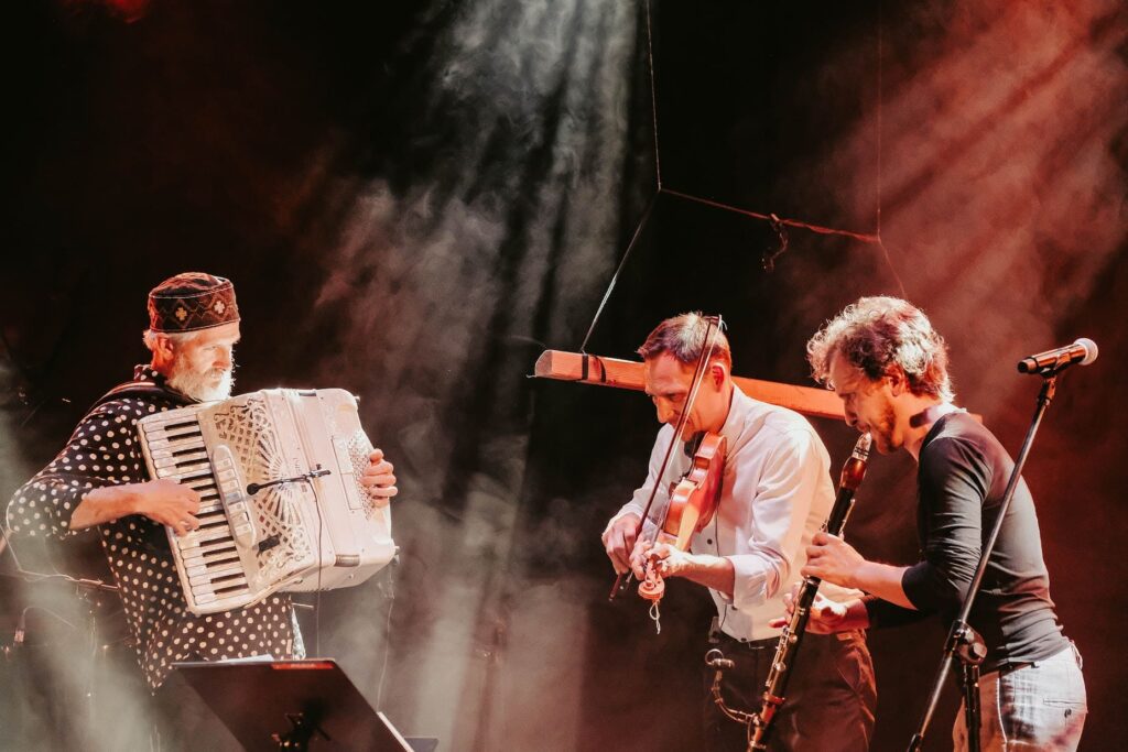 Muzycy grający na akordeonie i skrzypcach.