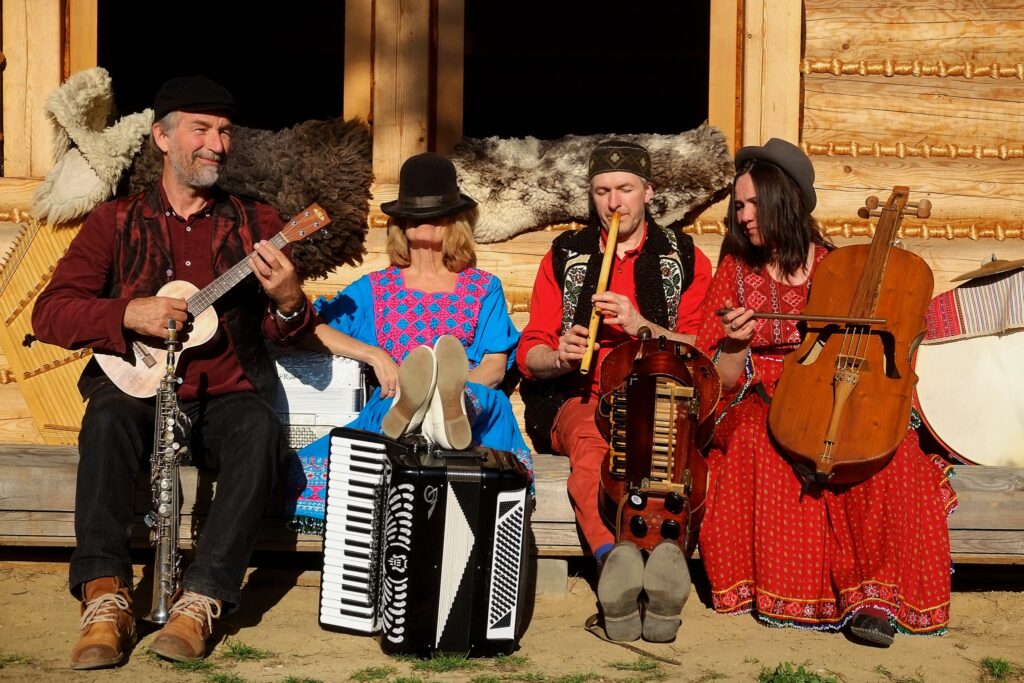 Muzycy w tradycyjnych strojach grają na instrumentach.