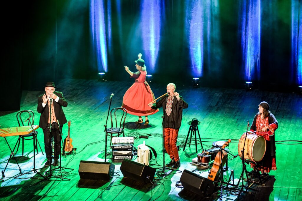 Muzycy podczas występu na scenie, kolorowe światła.
