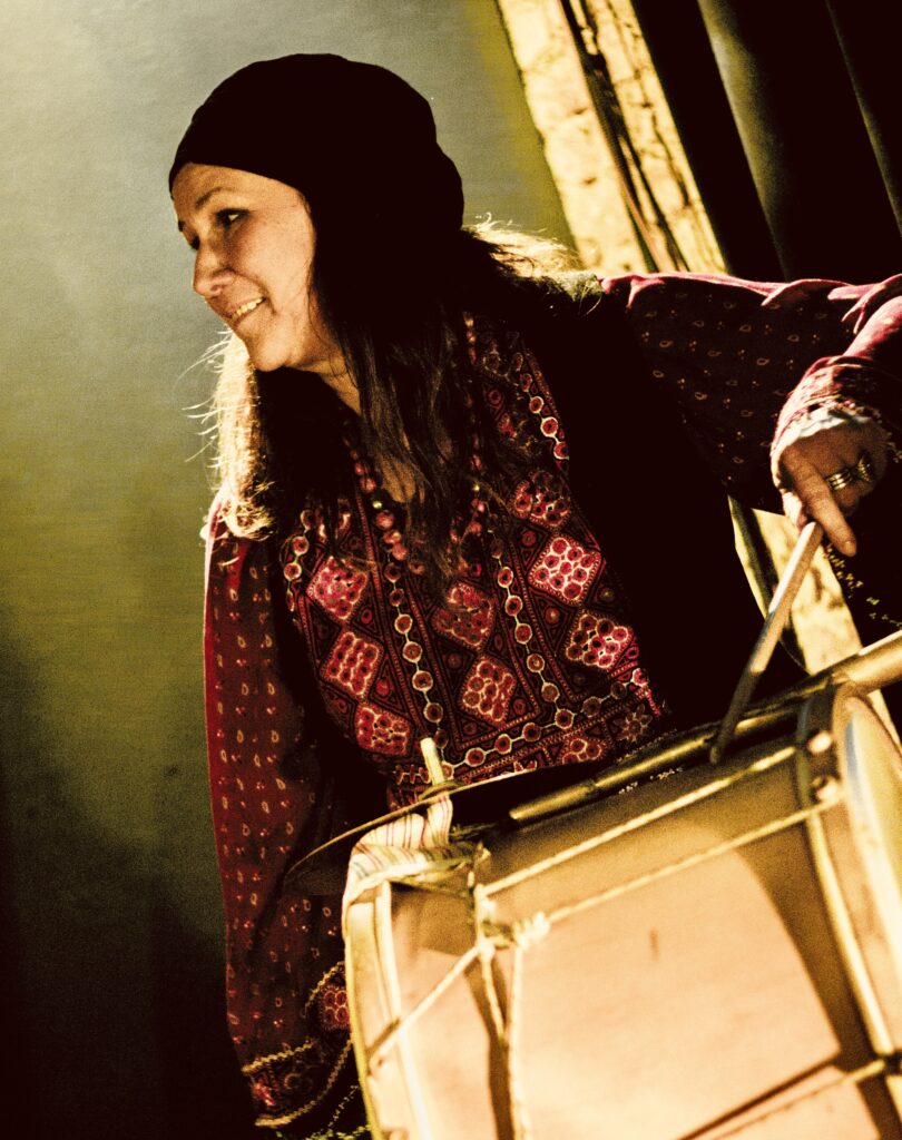 Muzykantka grająca na bębnie w tradycyjnym stroju.