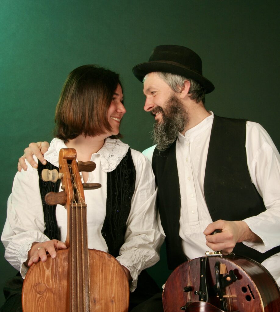 Muzycy z instrumentami, przyjazna interakcja na zdjęciu.