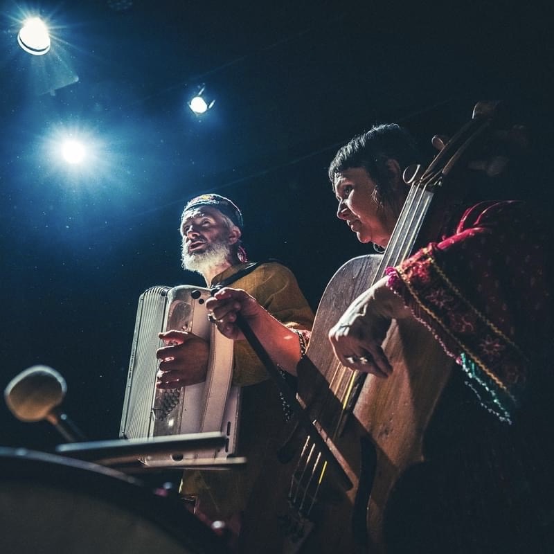 Muzycy grający na instrumentach na scenie.