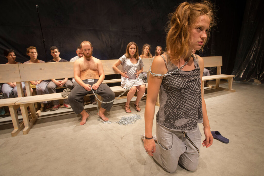 Artystyczna scena w spektaklu teatralnym z łańcuchami.