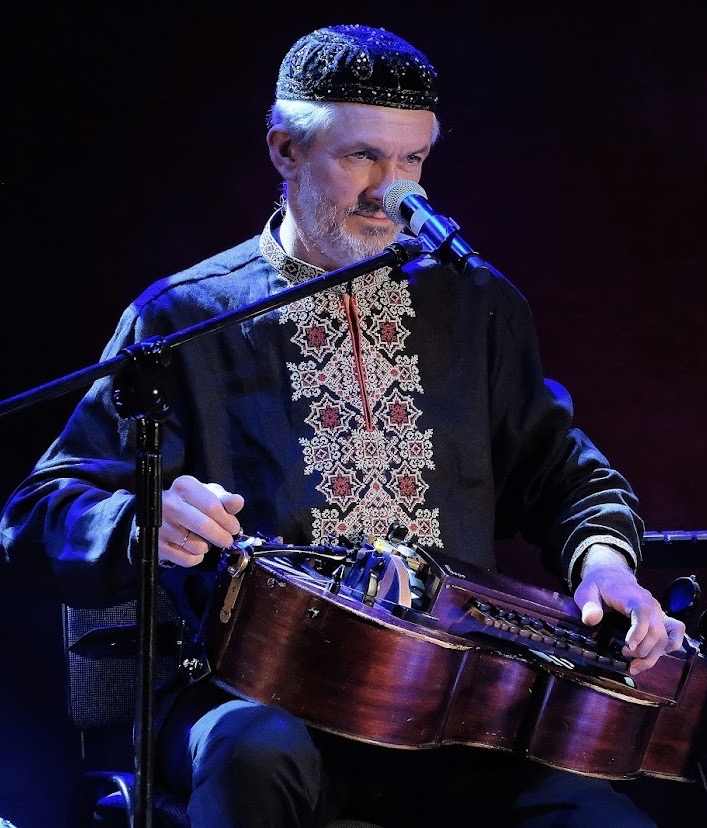 Muzyk grający na instrumencie na scenie.