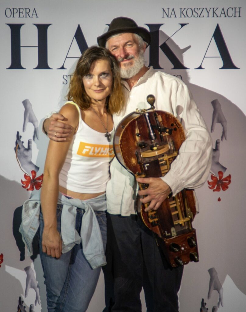 Para na tle plakatu opery Hańba