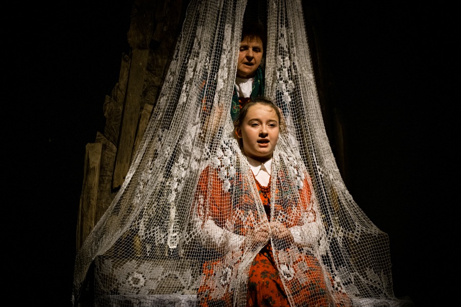 Scena teatralna z kobietami w tradycyjnych strojach.