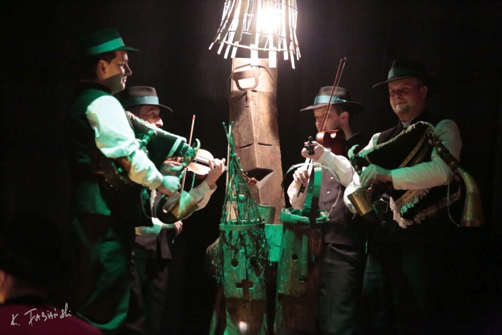 Muzycy grający na tradycyjnych instrumentach w ciemności.