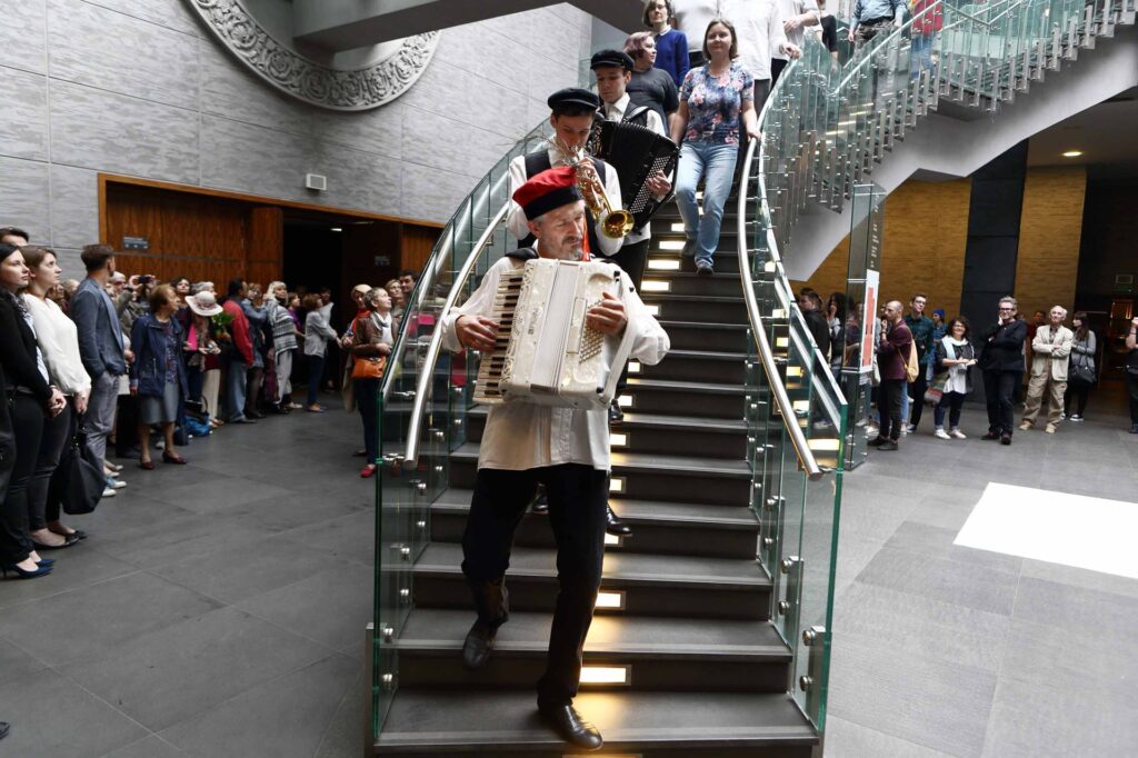 Mężczyzna gra na akordeonie schodząc po schodach.
