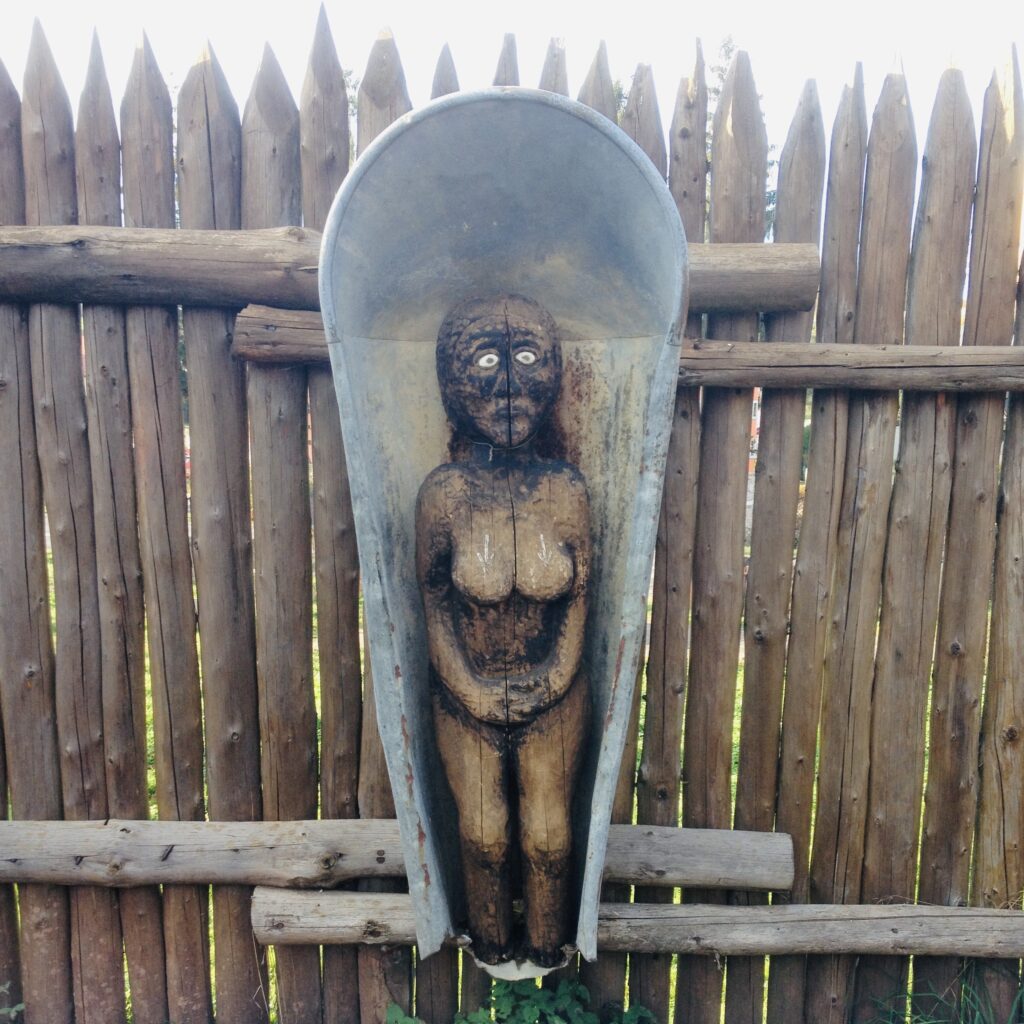 Rzeźba przedstawiająca kobiecą postać w drewnie.