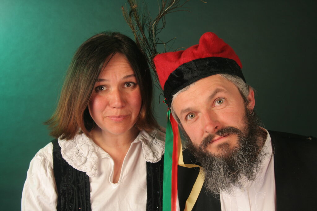 Dwoje ludzi w tradycyjnych polskich strojach ludowych.