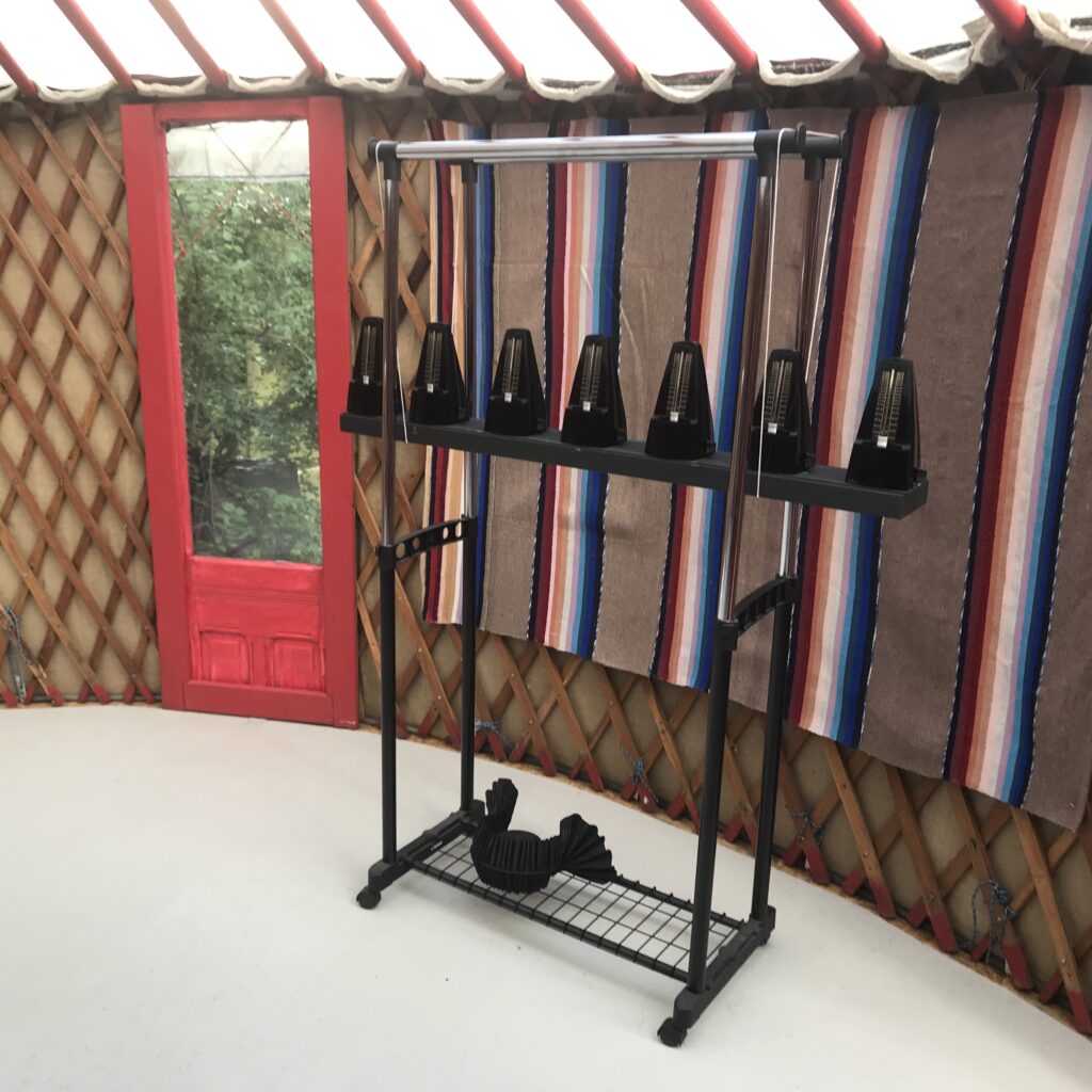 Wnętrze jurtu z czerwonymi drzwiami i dekoracjami.