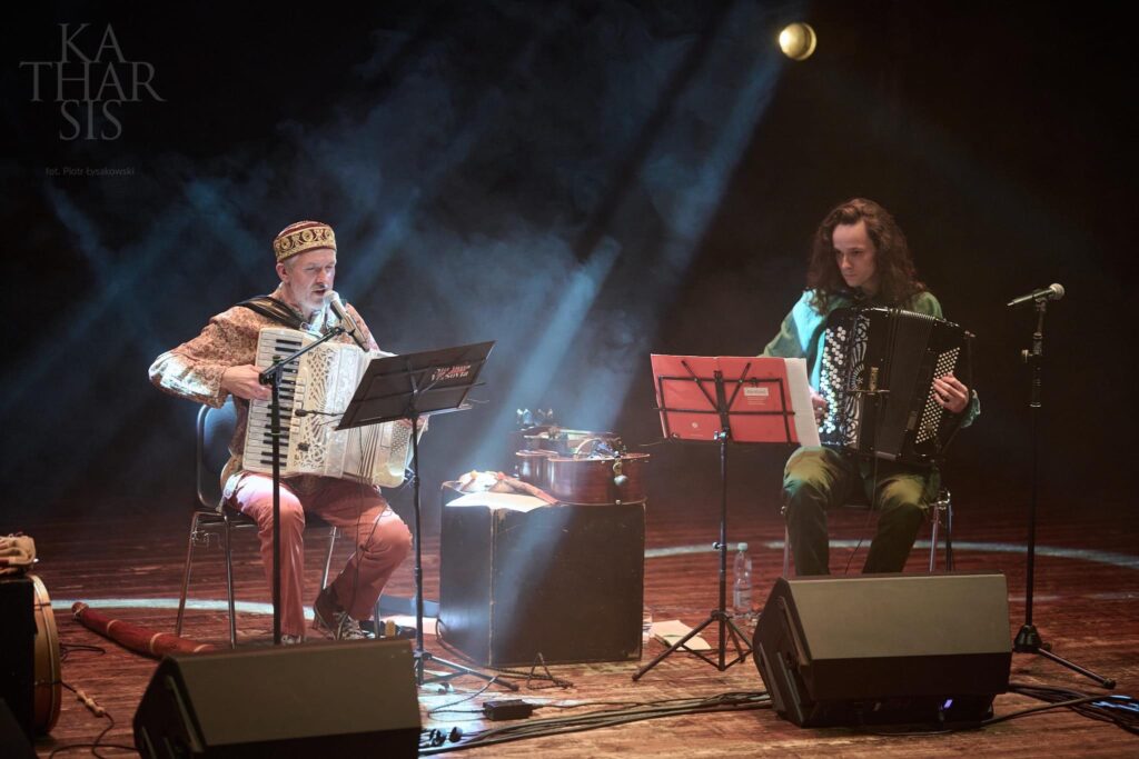 Dwóch muzyków grających na akordeonach na scenie