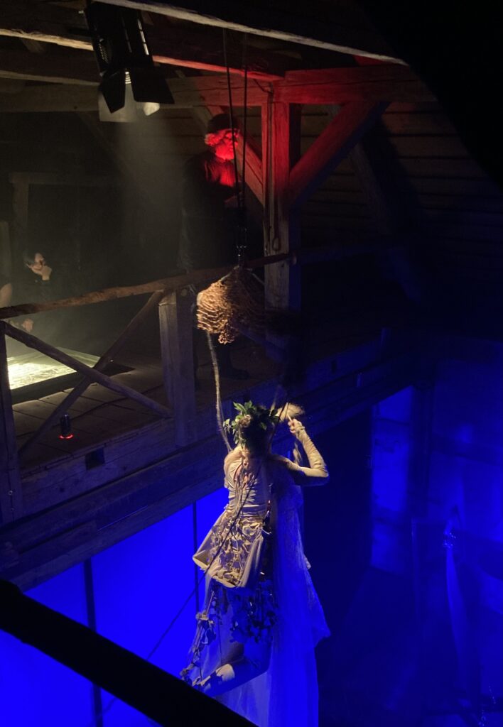 Scena teatralna z postacią w misternej kostiumie.