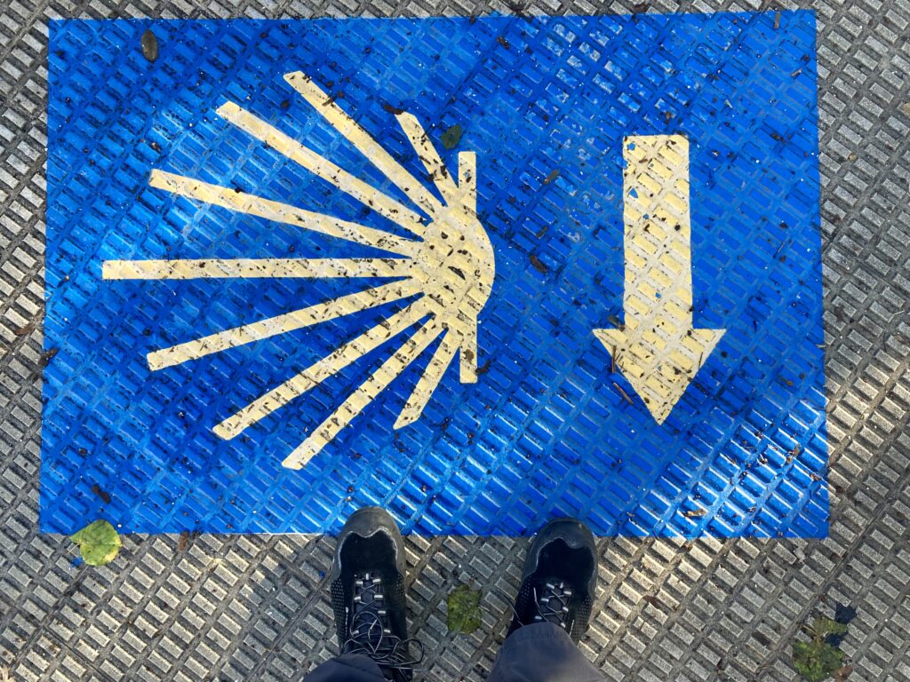 Symbol szlaku pielgrzymkowego na niebieskim tle