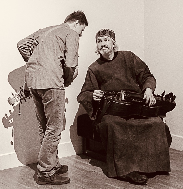 Dwaj mężczyźni rozmawiają w artystycznej przestrzeni.