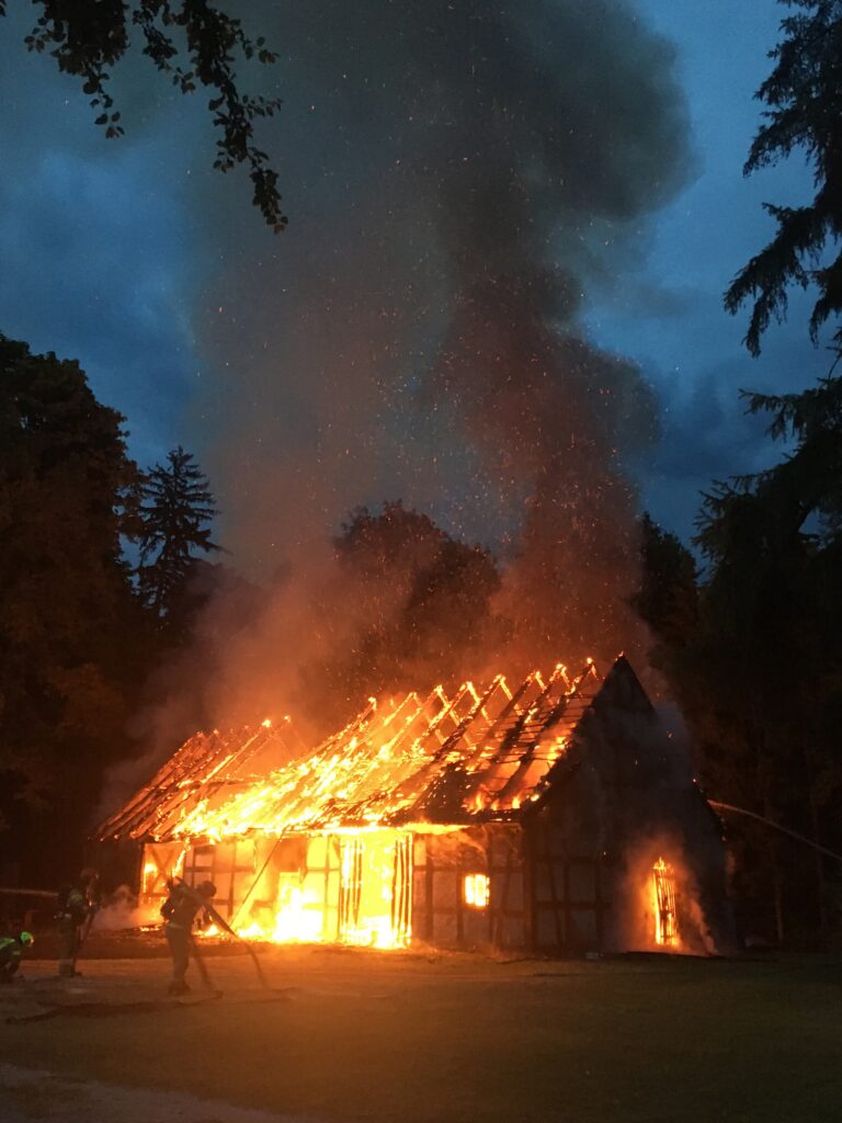 Płonący budynek podczas akcji gaśniczej.