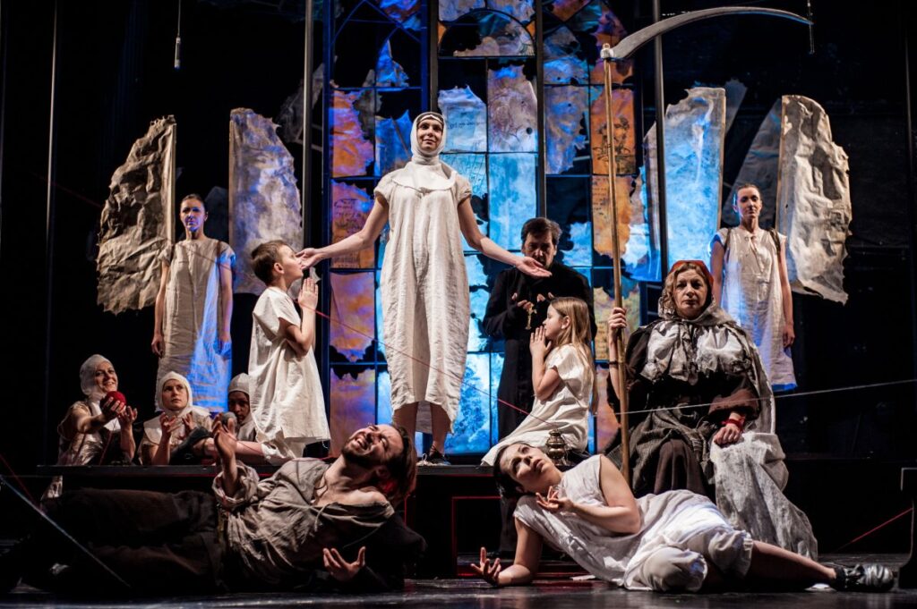 Scena teatralna z aktorami w kostiumach.