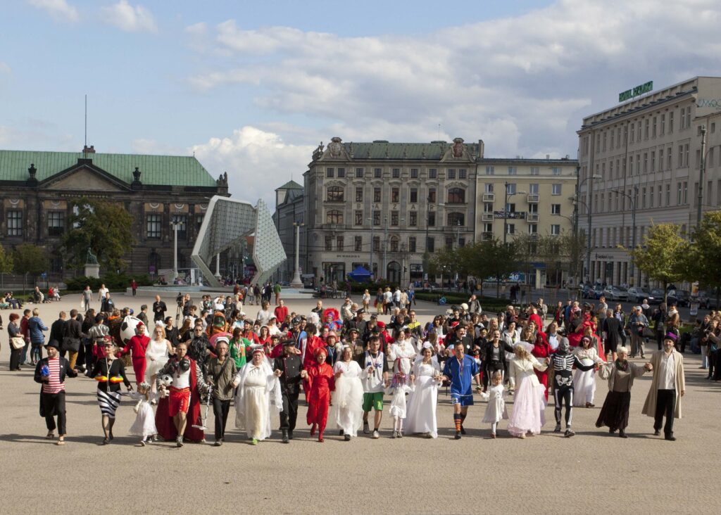 Grupa ludzi w kostiumach na miejskim festiwalu.